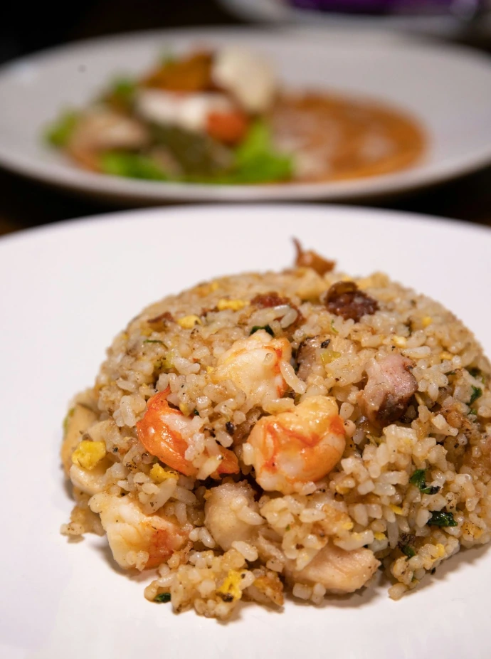 cooked rice with green peas and sliced carrots on white ceramic plate